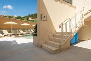 a staircase leading up to a house with a swimming pool at Borgo Myricae - Giglio in Chia