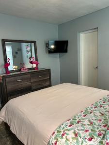a bedroom with a bed and a dresser with a mirror at Coastal Bungalows--The Flamingo Bungalow in Fort Lauderdale +10 photos