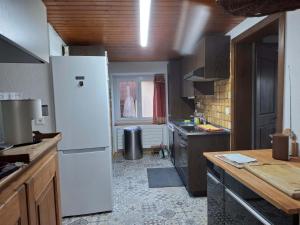 a kitchen with a white refrigerator and a counter at Maison mitoyenne avec terrasse in Asuel