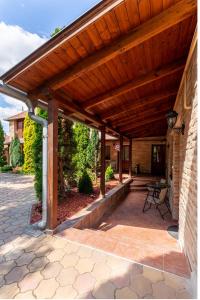 an outdoor patio with a wooden pergola at Varázskő Apartman in Gyula
