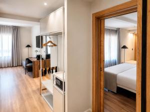 a bedroom with a bed and a desk and a mirror at Hotel La Palloza in Lugo +34 photos