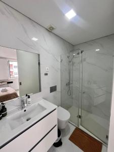 a bathroom with a sink and a shower and a toilet at Casa Augusta 6 in Braga