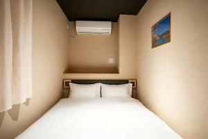 a small bedroom with a bed and a air conditioner at SORA雷門 Hotel in Tokyo +30 photos