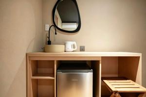 a kitchen with a counter with a mirror and a refrigerator at SORA雷門 Hotel in Tokyo