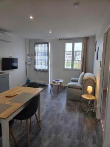 a living room with a table and a couch at Les Gîtes de Guillonnet in Anglade
