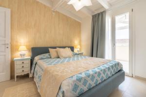 a bedroom with a bed and a large window at Borgo Myricae - Giglio in Chia +18 photos