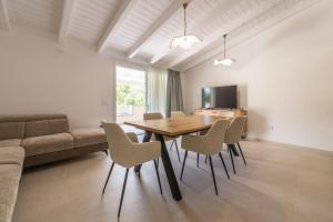 a dining room with a table and chairs and a couch at Borgo Myricae - Giglio in Chia