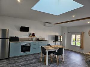 a kitchen with a table and a kitchen with a skylight at Les Gîtes de Guillonnet in Anglade +22 photos