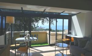 a living room with a large window with a couch and a table at Villa ALFONSA in Saint-Raphaël