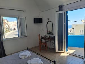 a room with a bed and a table with a view at Villa Firostefani in Firostefani