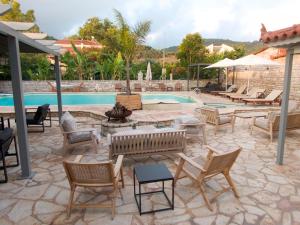 a patio with a bunch of chairs and a pool at Kaiafas Lake Hotel in Kaiafas