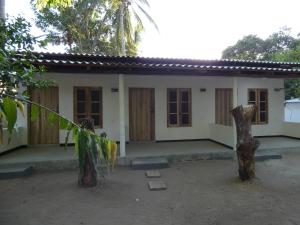 a house with two trees in front of it at Mango Surf House in Arugam Bay