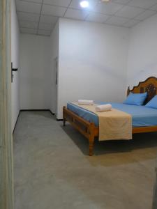 a bedroom with a bed with blue sheets and blue pillows at Mango Surf House in Arugam Bay +9 photos