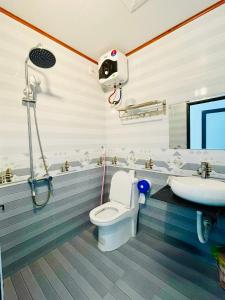a bathroom with a toilet and a sink at Nhà nghỉ Lena Quan Lạn in Quan Lạn