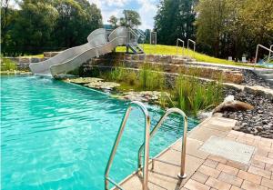 a swimming pool with a slide in a park at Ferienwohnung Katzenberg in Bad Soden-Salmünster
