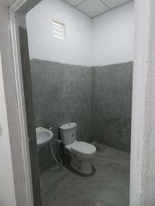 a bathroom with a toilet and a sink at Mango Surf House in Arugam Bay