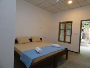 a bedroom with a bed with two pillows on it at Mango Surf House in Arugam Bay