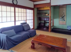 a living room with a blue couch and a coffee table at 和庵-Nagomian- in Kasaoka