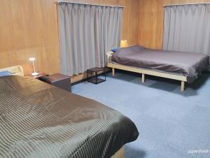 a hotel room with two beds and a window at 和庵-Nagomian- in Kasaoka