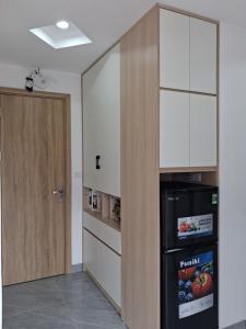 a room with a kitchen with a refrigerator and a door at Lumina Homes 2 Lai Xá in Thuong Thon