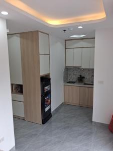 a kitchen with white cabinets and a black refrigerator at Lumina Homes 2 Lai Xá in Thuong Thon