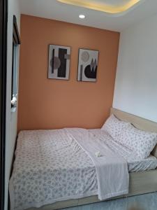 a bedroom with a bed with two pictures on the wall at Lumina Homes 2 Lai Xá in Thuong Thon