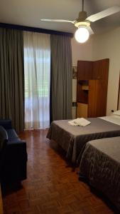 a hotel room with two beds and a window at Locanda El Piron in Chiampo