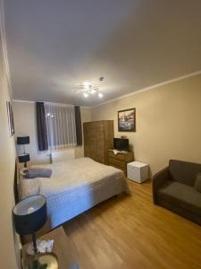 a small bedroom with a bed and a couch at Kevevára Vendégház in Ráckeve
