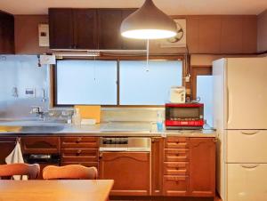 a kitchen with wooden cabinets and a white refrigerator at 和庵-Nagomian- in Kasaoka
