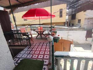 a balcony with a red umbrella and a table at Kashmir naaz in Srinagar