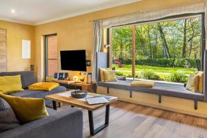 a living room with a large window and a couch at Ferienhäuser im Sternenpark am See in Lochow