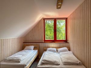 two beds in a room with a window at Willa Hacienda in Międzybrodzie Żywieckie