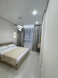 a bedroom with a large bed and a window at ЖК Ұлы Дала in Shymkent
