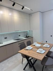 a kitchen with a wooden table and chairs at ЖК Ұлы Дала in Shymkent