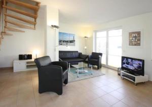 a living room with a couch and a tv at Hanne-Hus in Kühlungsborn