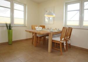 a dining room with a wooden table and chairs at Hanne-Hus in Kühlungsborn +2 photos