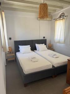 two beds in a room with white sheets at GLAFKY Retreat in Panormos +22 photos