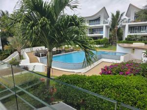 a resort with a swimming pool and a building at Oceanfront in Azuri in Roches Noires