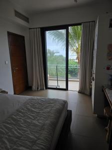 a bedroom with a bed and a large window at Oceanfront in Azuri in Roches Noires +19 photos