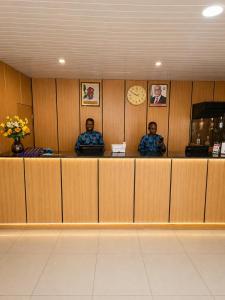 two men sitting at a counter in a waiting room at Royalbirds Motel in Akure