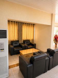 a living room with leather chairs and a table at Royalbirds Motel in Akure