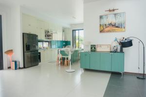 a large kitchen with green cabinets and appliances at Luxury Mi-a Villa LaGi 4pn, huge salted pool, outdoor bbq and kara, up to 20 in Lagi