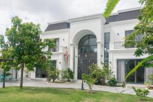 a white house with a black door at Luxury Mi-a Villa LaGi 4pn, huge salted pool, outdoor bbq and kara, up to 20 in Lagi