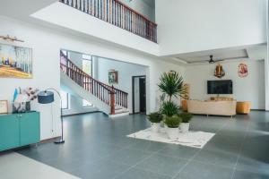 a large living room with a staircase and potted plants at Luxury Mi-a Villa LaGi 4pn, huge salted pool, outdoor bbq and kara, up to 20 in Lagi