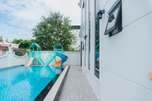 a swimming pool with a slide next to a house at Luxury Mi-a Villa LaGi 4pn, huge salted pool, outdoor bbq and kara, up to 20 in Lagi
