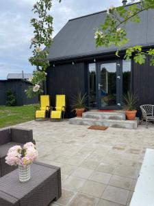 a patio with yellow chairs and a table at Chill Out Carnikava in Carnikava +46 photos