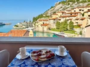 a plate of food on a table with a view at Portopiccolo Apartments in Sistiana