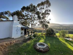 a small white house with a circle in the grass at Cornellskop Country Stay in Botrivier