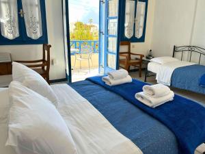 a bedroom with two beds with towels on them at Irigeneia Hotel in Perissa
