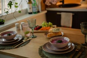 a table with two bowls of soup and a plate of food at Chill Out Carnikava in Carnikava